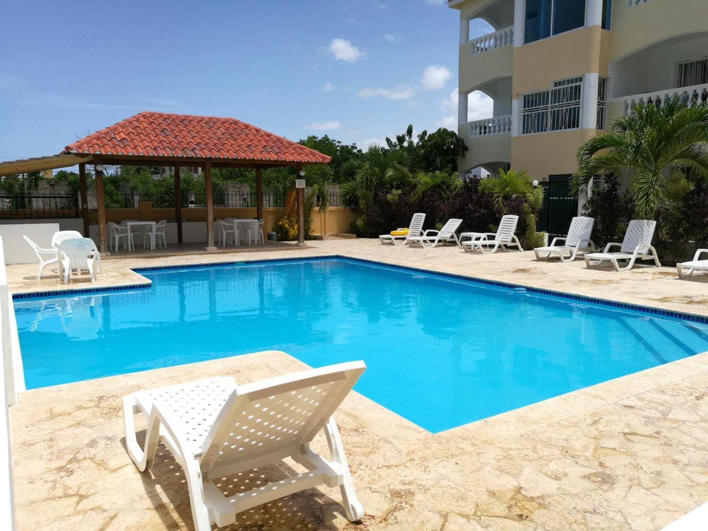 Swimming pool with lounge chairs and a red-tiled gazebo