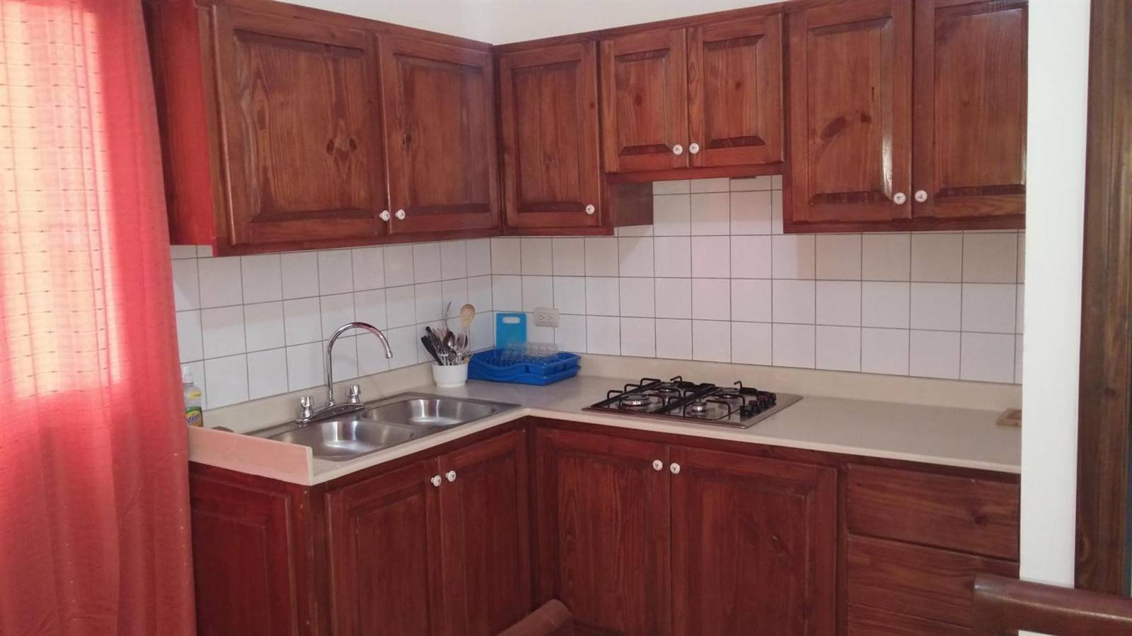 Fitted kitchen with wooden cabinets, a sink and a gas hob